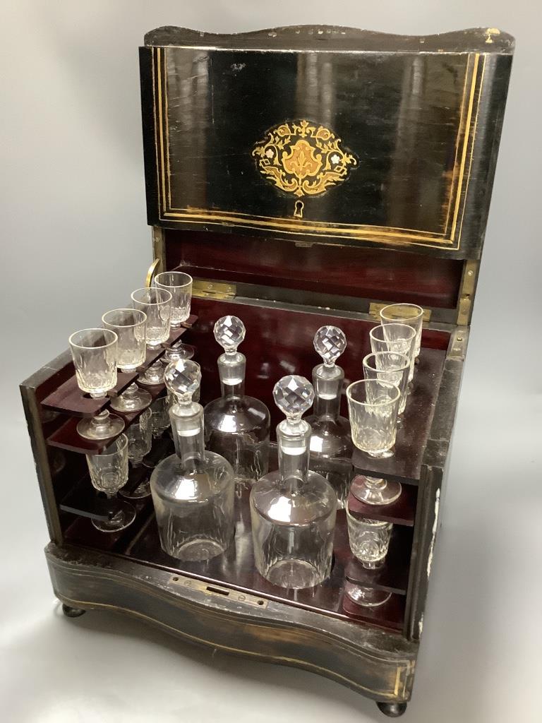 A French ebonised decanter case, c.1870, hinged lid opening to reveal four liqueur decanters and stoppers together with sixteen liqueur glasses, height 28cm